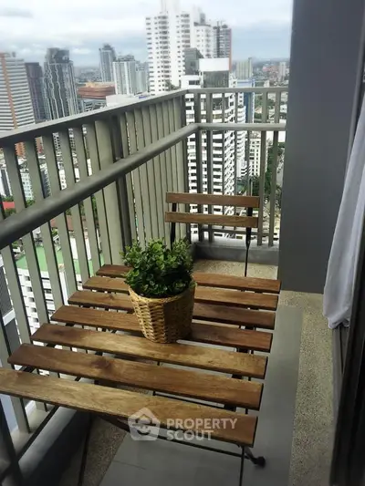 Charming city view balcony with wooden furniture and potted plant, perfect for relaxation.