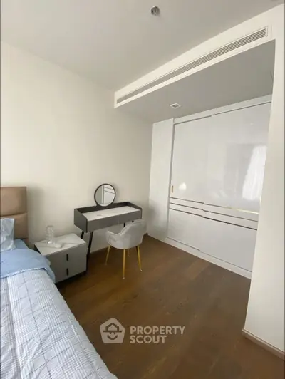 Modern bedroom with sleek furniture and wooden flooring