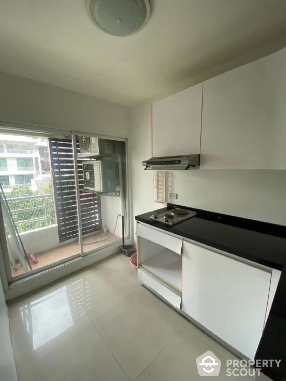 Modern kitchen with sleek cabinetry and balcony access in urban apartment