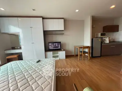 Modern studio apartment with wooden flooring and compact kitchen area