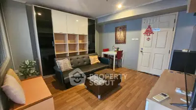 Cozy living room with modern decor and wooden flooring, featuring a stylish sofa and ample storage space.