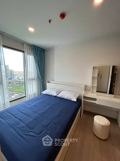 Modern bedroom with city view, featuring a cozy bed and stylish vanity.