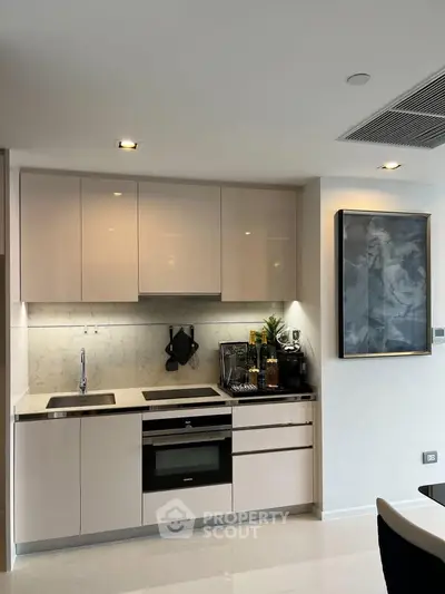 Modern kitchen with sleek cabinetry and built-in appliances in a stylish apartment.