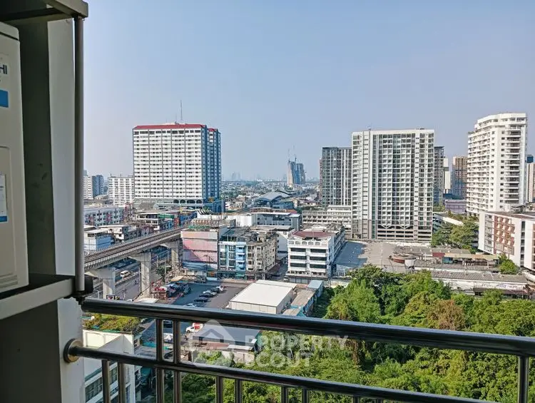 Stunning cityscape view from a high-rise balcony overlooking urban skyline and lush greenery.
