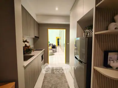 Modern kitchen with sleek cabinetry and open layout leading to a cozy living area.