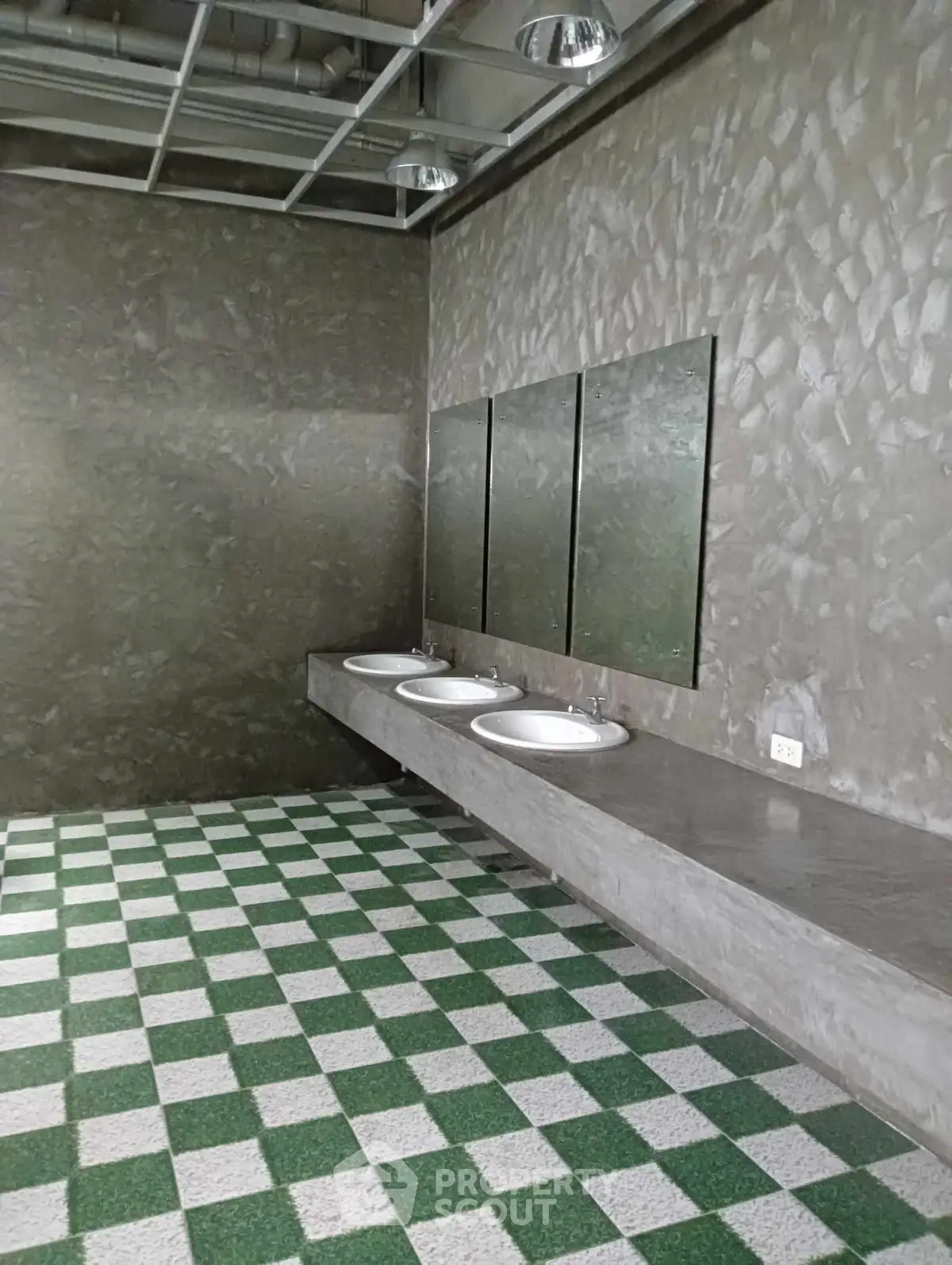 Modern industrial-style bathroom with concrete finishes and checkered flooring.