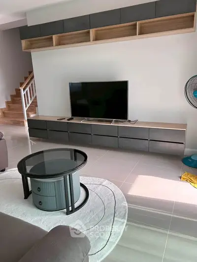 Modern living room with sleek TV unit and stylish coffee table, showcasing contemporary interior design.