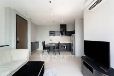 Modern open-plan living room with sleek kitchen and stylish furniture in a contemporary apartment.