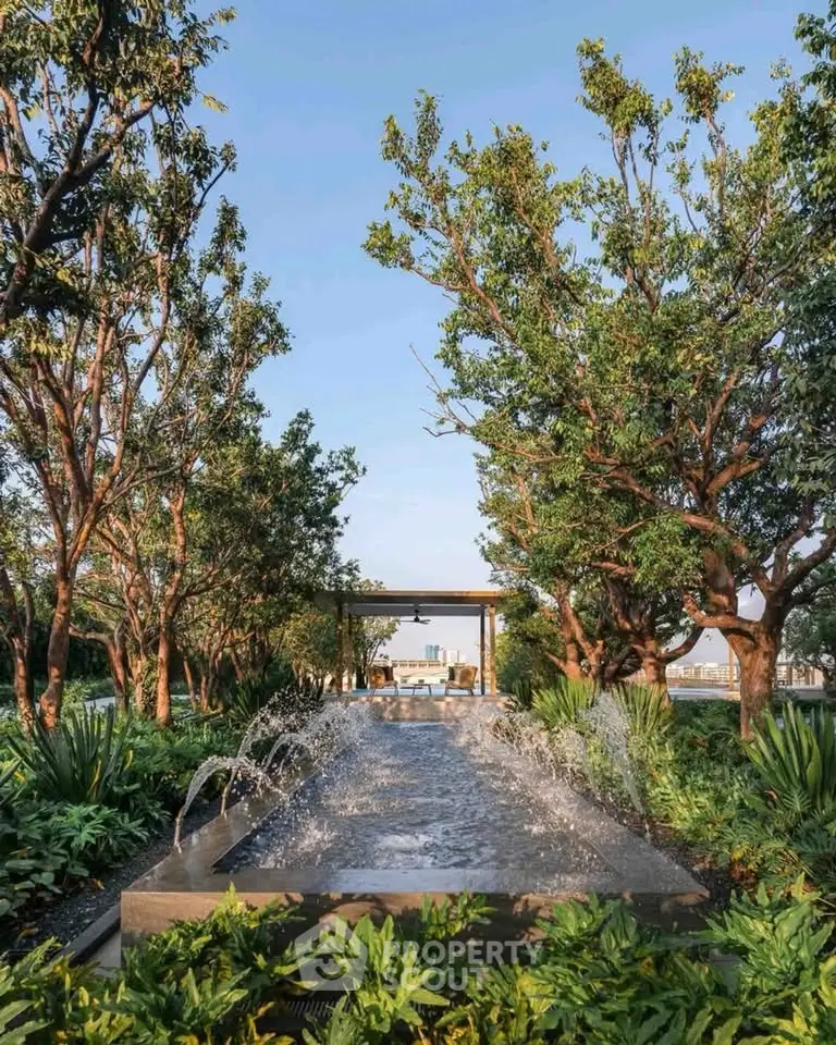 Luxurious garden with water feature and lush greenery in upscale real estate setting.