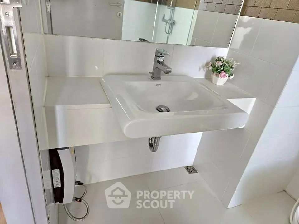 Modern bathroom with sleek white sink and stylish fixtures, perfect for contemporary living.