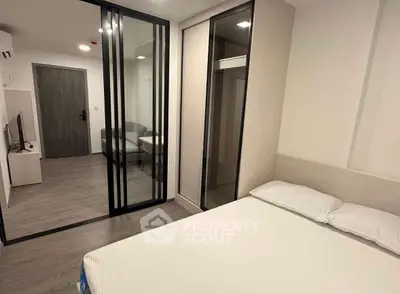 Modern bedroom with sliding glass doors and minimalist decor in a stylish apartment.