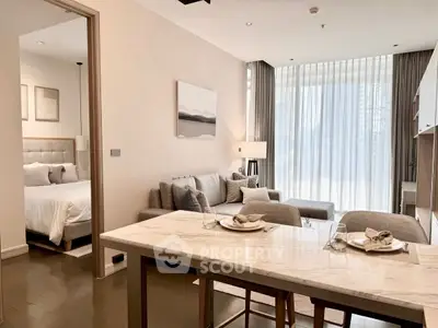 Modern open-plan living room with elegant dining area and cozy bedroom view.