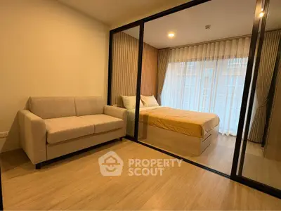 Modern bedroom with glass partition and cozy sofa in a stylish apartment.