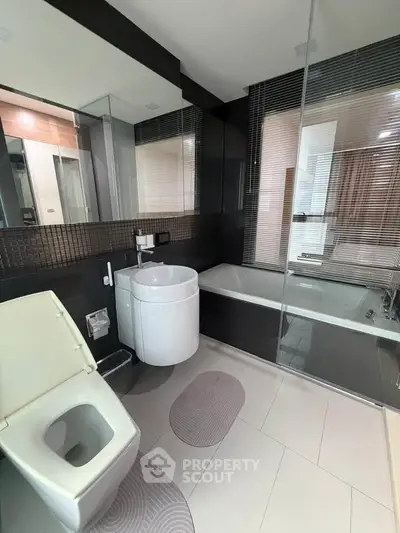 Modern bathroom with sleek design, featuring a bathtub and stylish fixtures.