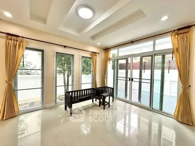 Spacious living room with large windows and elegant curtains, perfect for natural light lovers.