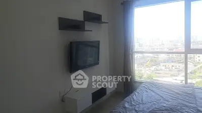Modern bedroom with wall-mounted TV and city view from large window.