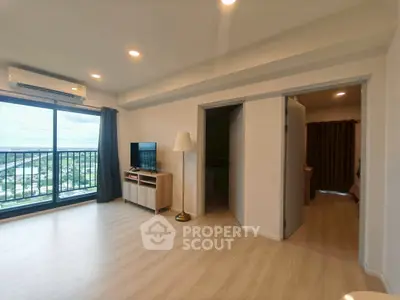 Spacious living room with balcony and modern decor, offering a stunning view.