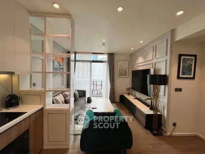 Modern living room with stylish decor and open layout, featuring a cozy seating area and large TV.