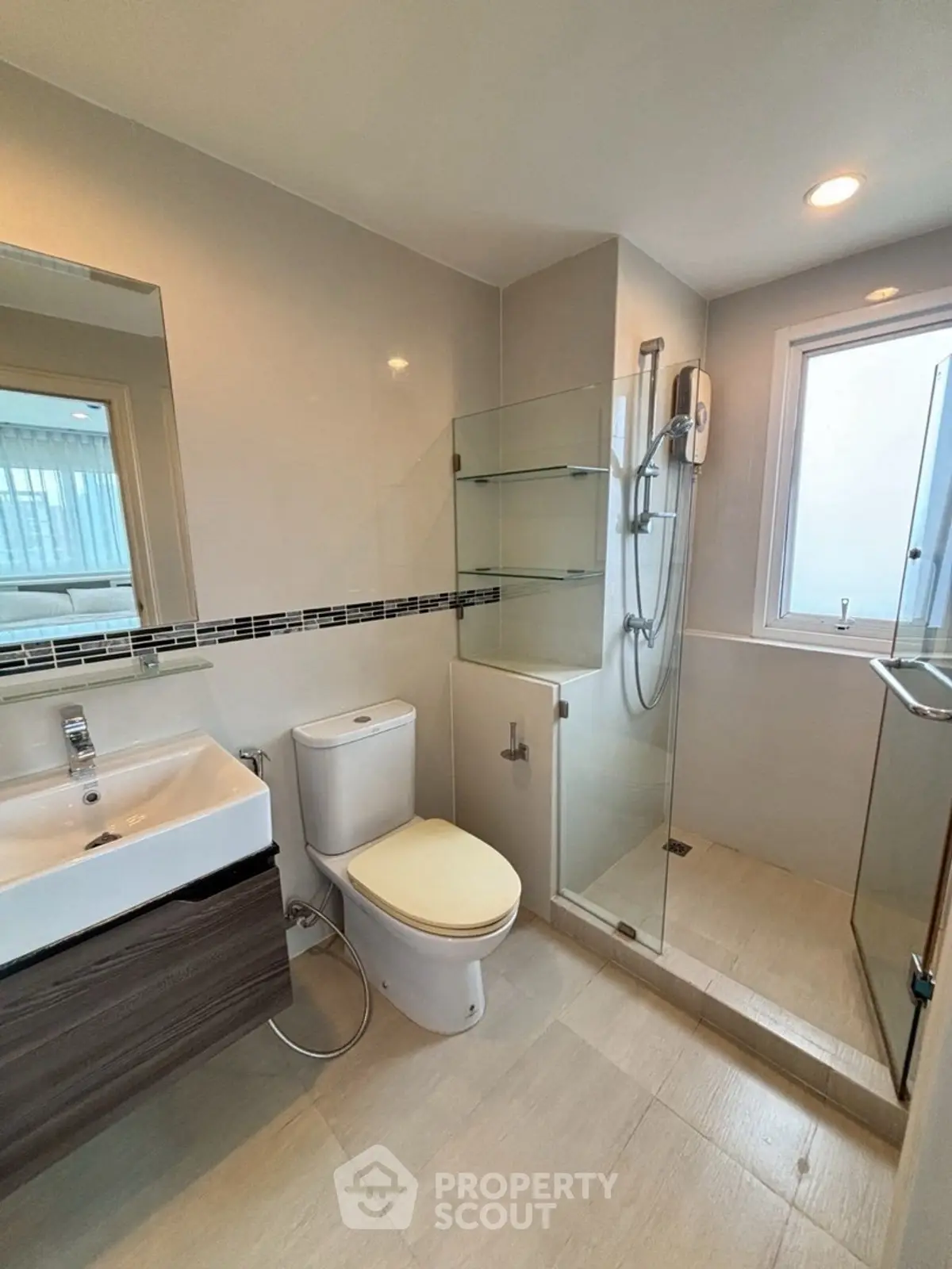 Modern bathroom with glass shower and sleek fixtures in a contemporary home.