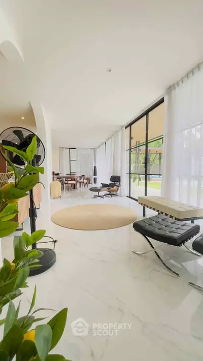 Luxurious modern living room with floor-to-ceiling windows and elegant furnishings.