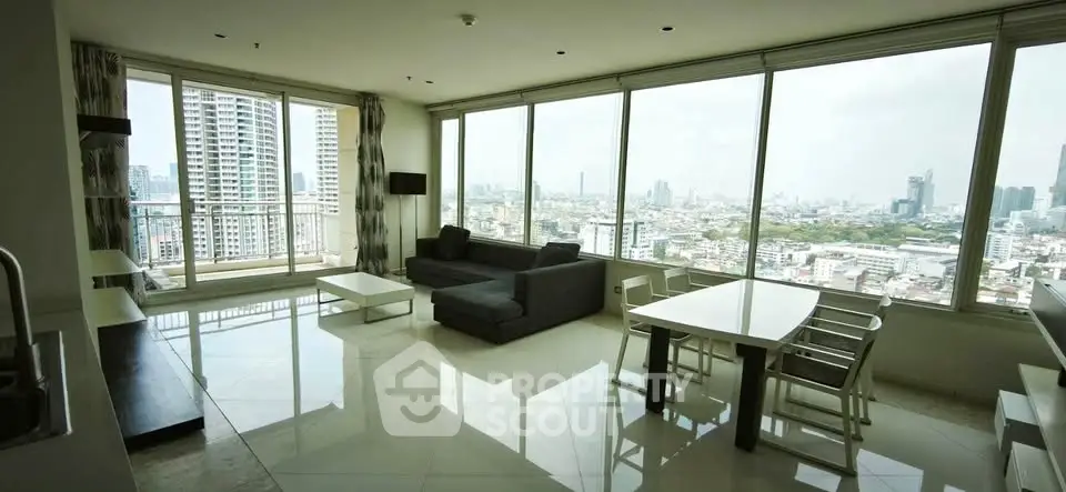 Spacious modern living room with panoramic city views and sleek furnishings.