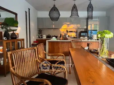 Chic modern kitchen with open layout, stylish wooden furniture, and elegant pendant lighting.