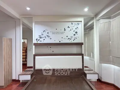 Modern bedroom with stylish wall art and wooden flooring, featuring built-in storage and elegant lighting.