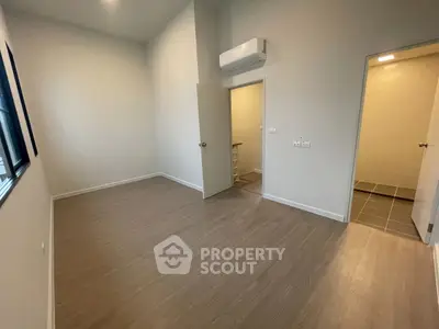 Spacious unfurnished bedroom with wooden flooring and air conditioning