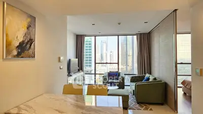 Modern living room with city view, stylish furniture, and open layout in high-rise apartment.