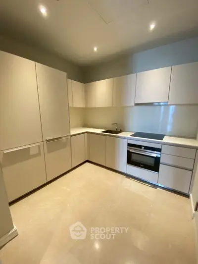 Modern kitchen with sleek cabinetry and built-in appliances in a contemporary apartment.