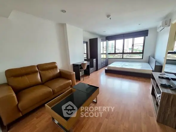 Spacious studio apartment with modern furnishings and large windows