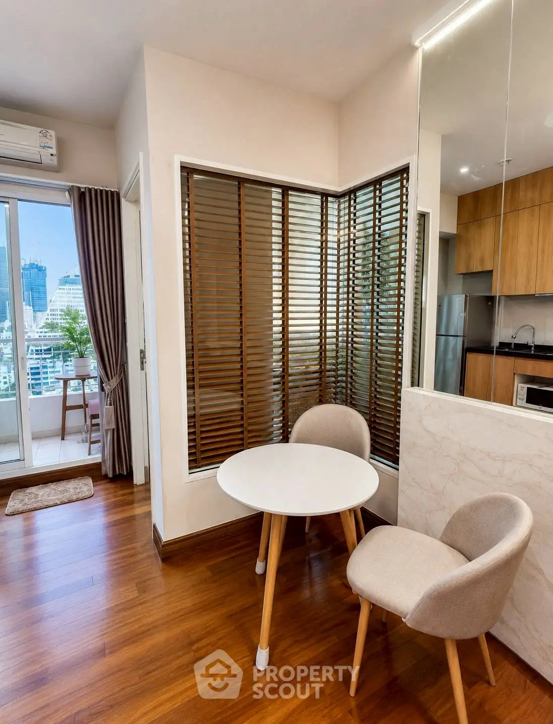 Modern apartment interior with cozy dining area and city view balcony