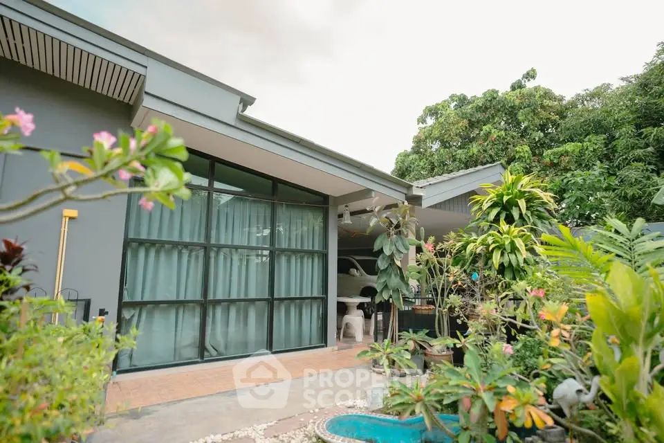 Charming modern home with lush garden and large windows, perfect for nature lovers seeking tranquility.