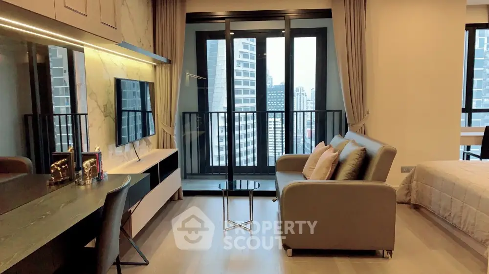 Modern studio apartment with balcony and city view, featuring sleek furniture and contemporary design.