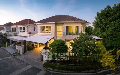 Stunning two-story house with modern design and lush greenery in a serene neighborhood.