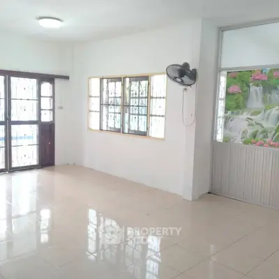Spacious empty room with tiled floor and large windows, ready for customization.