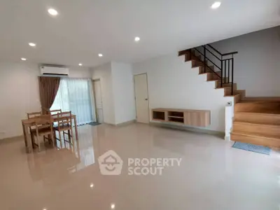Spacious modern living room with dining area and wooden staircase