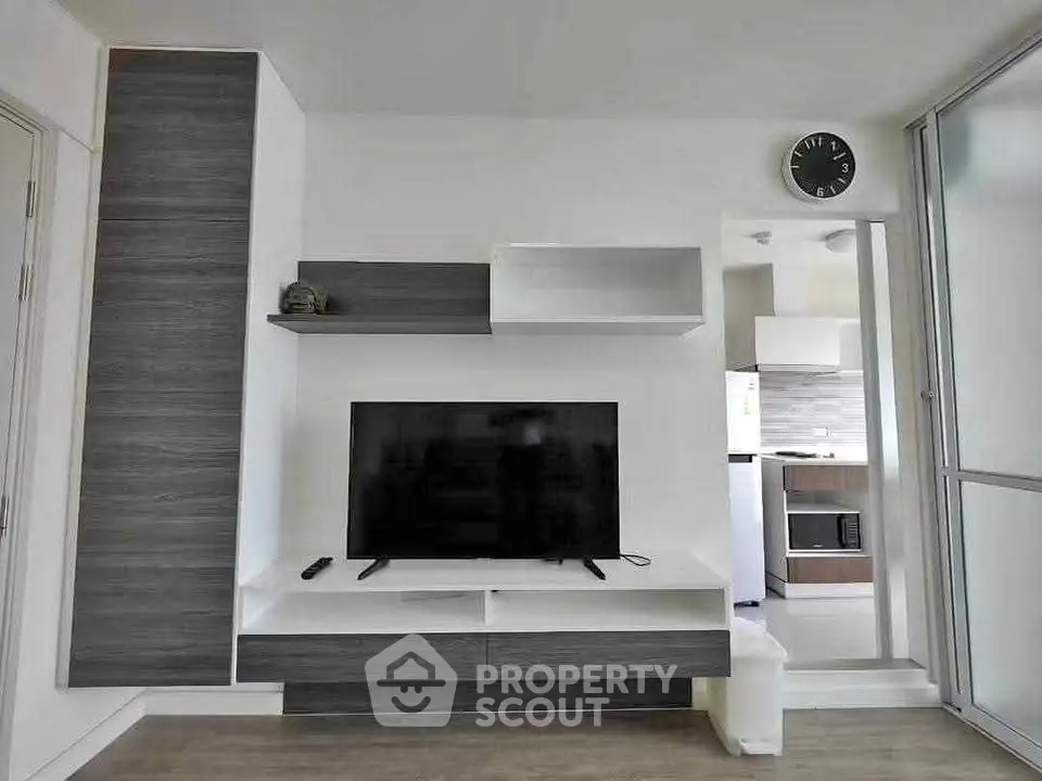 Modern living room with sleek TV unit and open kitchen layout