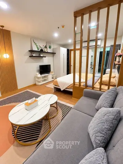Modern living room with cozy sofa, stylish coffee table, and open layout to bedroom.