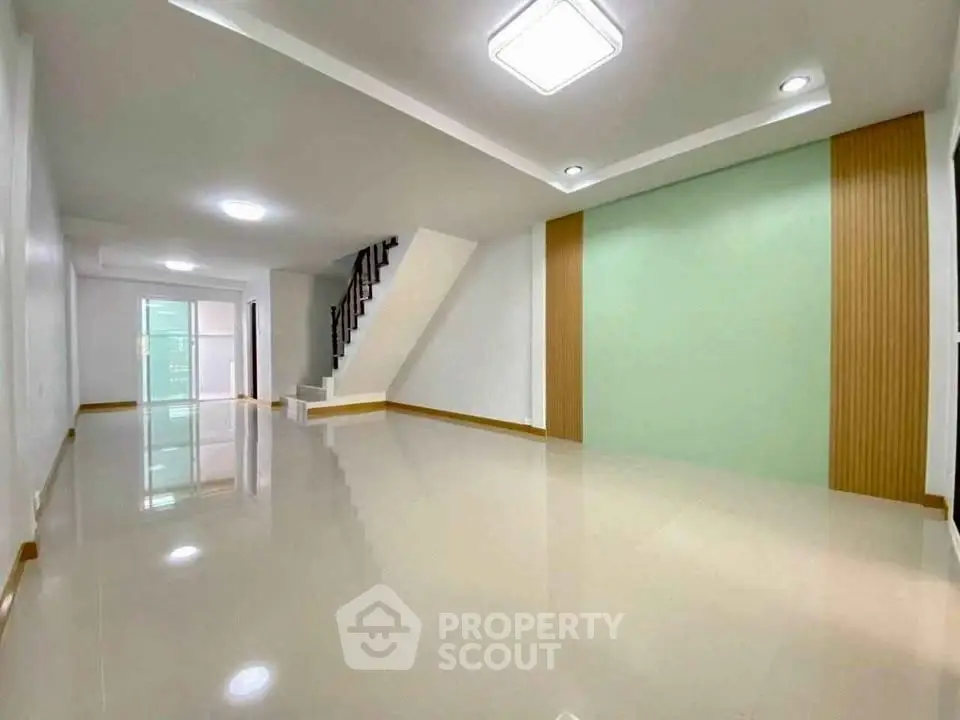 Spacious modern living room with sleek staircase and elegant design.