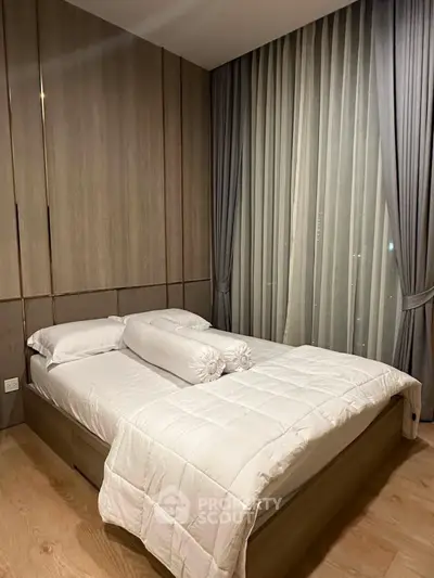 Modern bedroom with elegant wood paneling and floor-to-ceiling curtains, featuring a cozy bed with plush bedding.