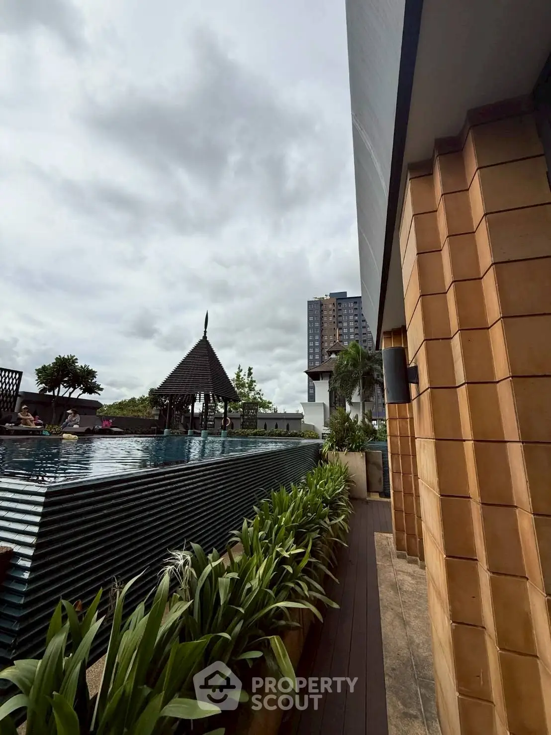 Luxurious rooftop pool with lush greenery and city views, perfect for relaxation and leisure.