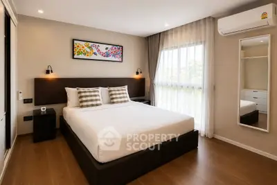 Modern bedroom with stylish decor, large window, and air conditioning in a cozy apartment.