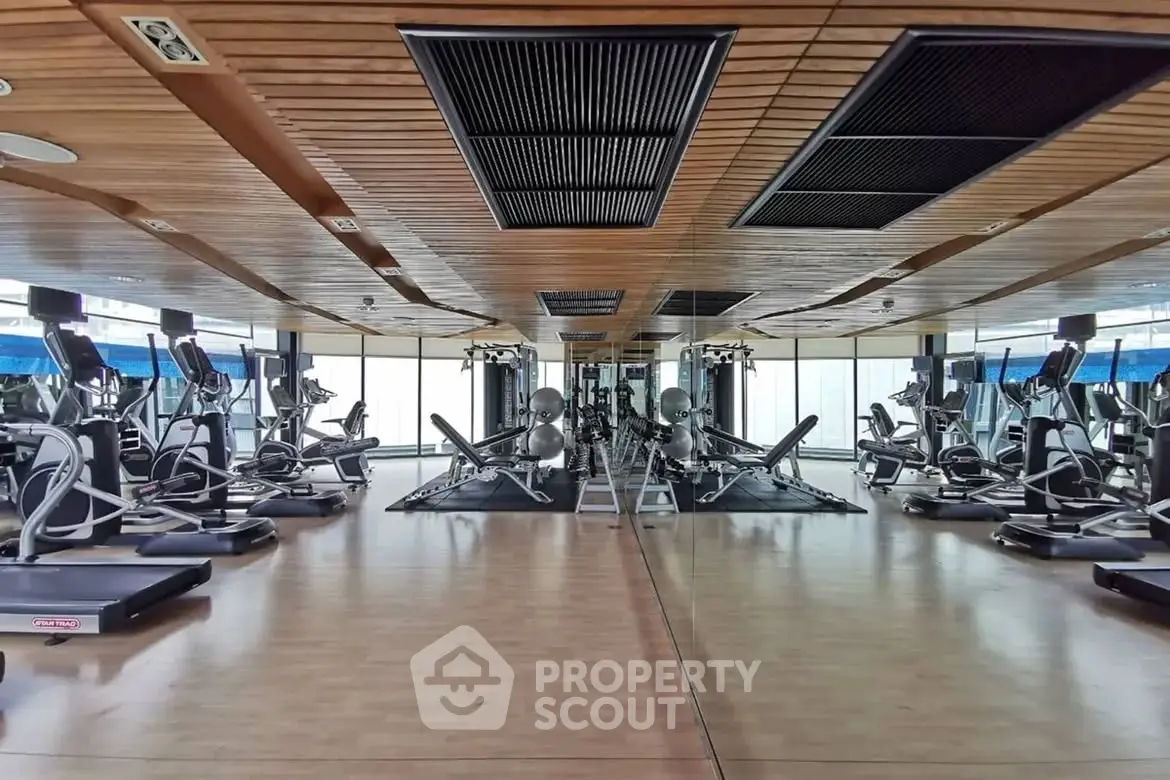 Spacious modern gym with state-of-the-art fitness equipment and mirrored walls.