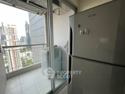 Modern balcony with city view featuring a fridge and washing machine, ideal for urban living.
