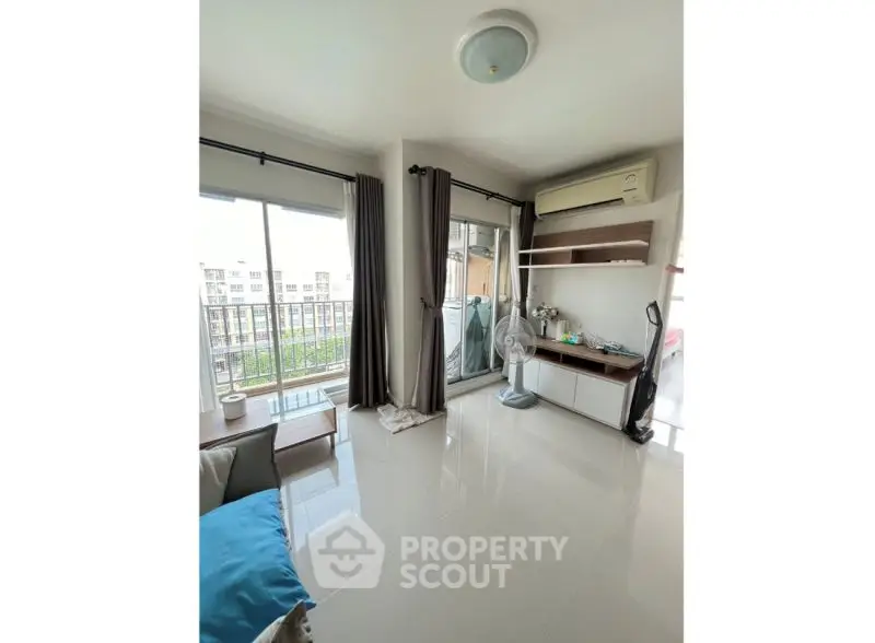 Bright living room with balcony access and modern furnishings in a stylish apartment.