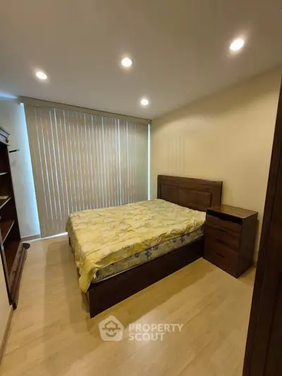 Cozy bedroom with wooden furniture and large window blinds