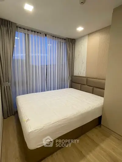 Modern bedroom with large window and elegant curtains in a stylish apartment.