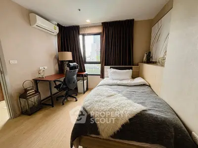 Cozy bedroom with modern desk and city view, perfect for urban living.