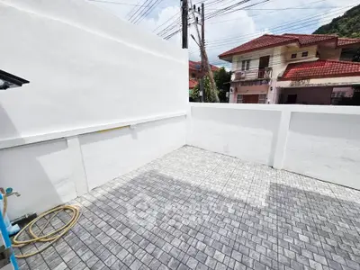 Spacious outdoor terrace with tiled flooring and white walls, perfect for relaxation or entertaining.
